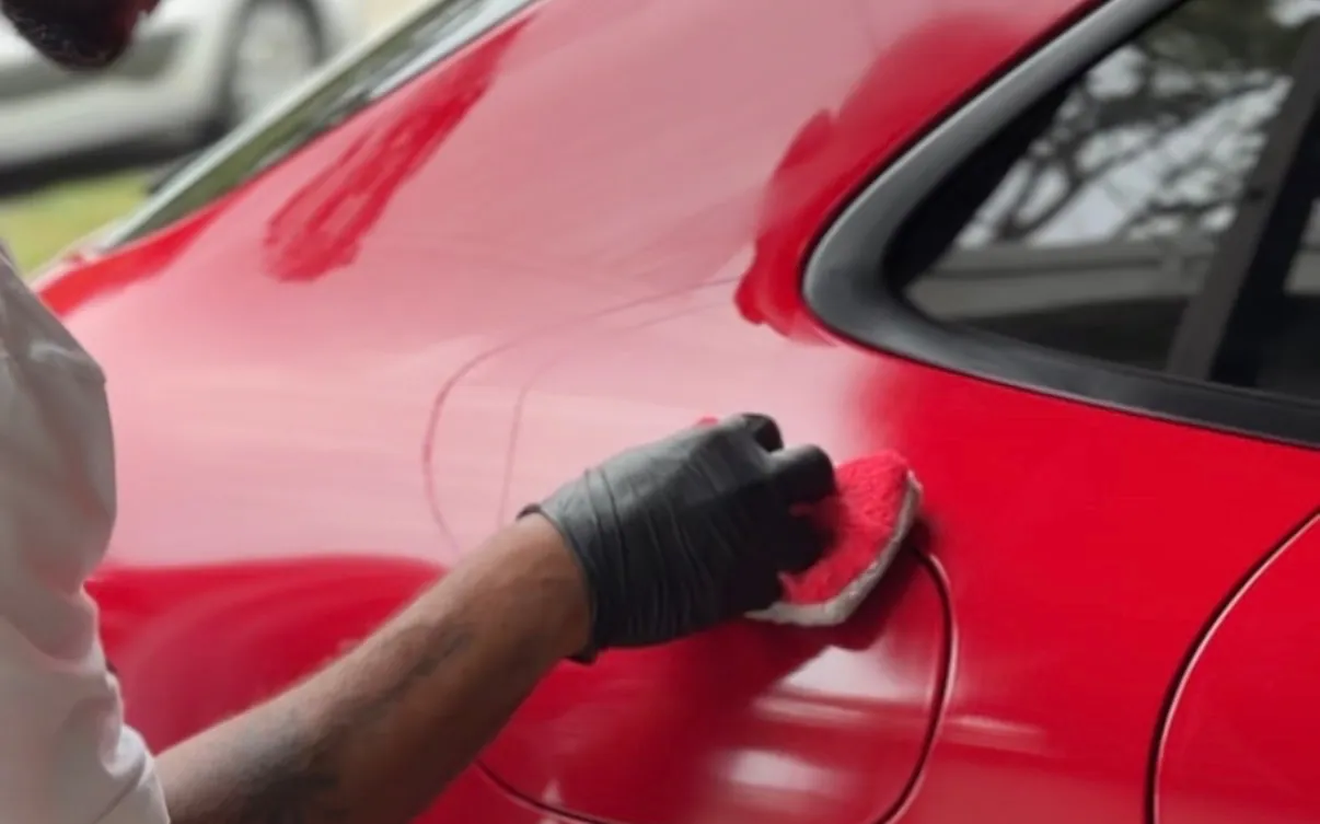 Gustavo applying ceramic coating to a panel by hand